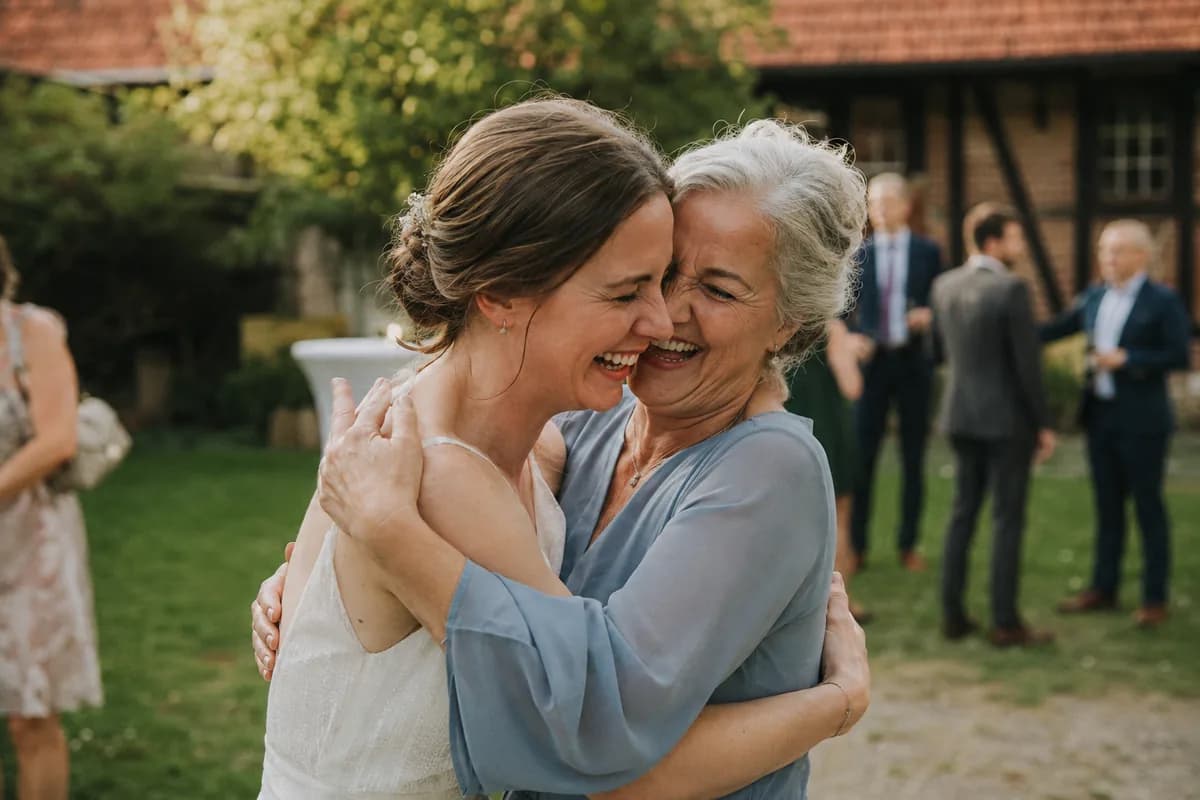 Bride hugging her mother at an outdoor wedding reception