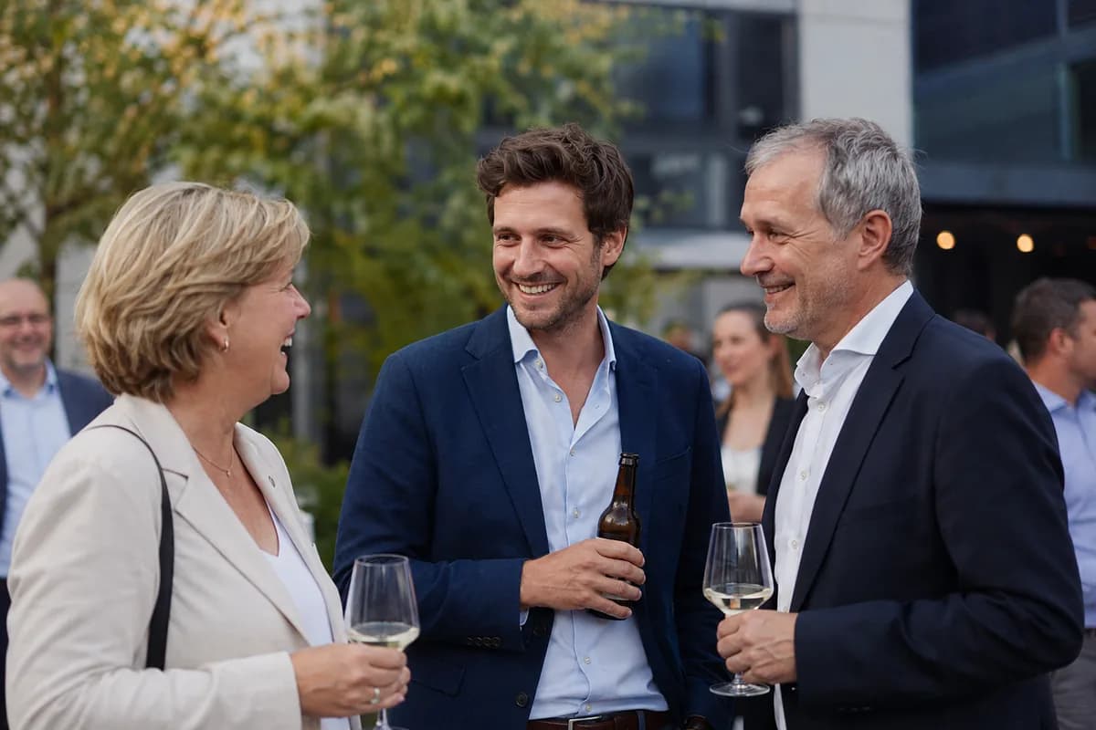 Colleagues laughing over drinks at a company reception